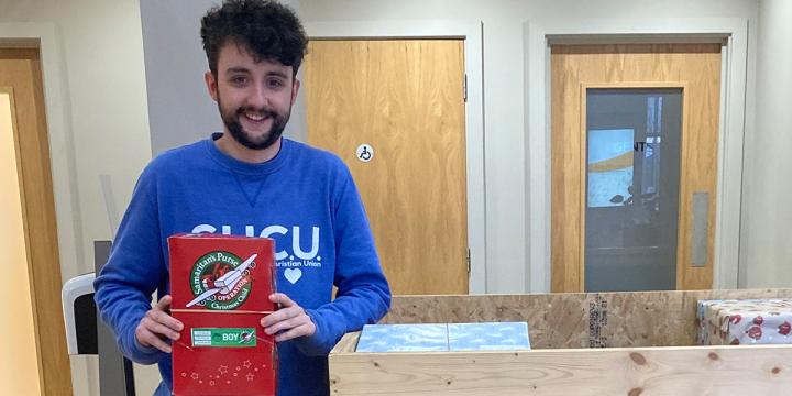Student dropping off shoebox at an official collection location